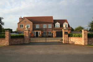 uma casa de tijolos com um portão e uma cerca em Labbadax House em Wisbech