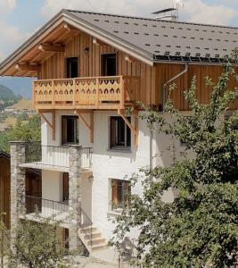 a house with a balcony on the side of it at Le Chalet des Fées in Valmorel