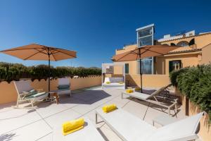 a patio with chairs and umbrellas on a roof at Fonda Llabres Boutique in Alcudia