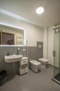a bathroom with a sink and a toilet and a mirror at QAL'AT Apart Hotel in Caltanissetta