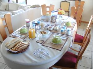 einen Tisch mit Essen darauf im Wohnzimmer in der Unterkunft Au fil de l'Eau in Saulzoir