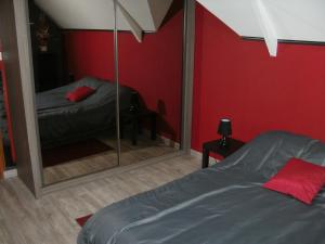 a bedroom with a mirror and a bed in it at Au fil de l'Eau in Saulzoir