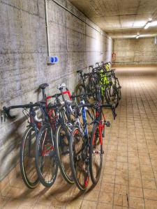 a row of bikes parked in a parking garage at Grem Bike Hostel in Premolo
