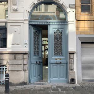 a blue door on a building with an arch at Maison d'Artiste in Ghent