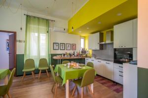 a kitchen with a table with a green table cloth at QAL'AT Cove in Caltanissetta
