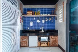 uma pequena cozinha com paredes de azulejos azuis e balcões em Economy Apart em Natal