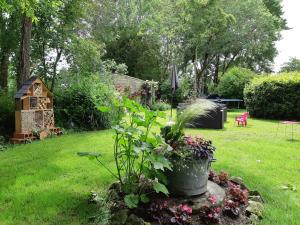 a garden with a pot of flowers and a bird house at Les 2 Madeleine in Saint-Saturnin-du-Bois