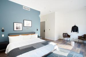 1 dormitorio con 1 cama grande y pared azul en Sonder The Queen, en Filadelfia