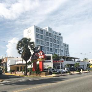 ein großes weißes Gebäude mit einem Schild davor in der Unterkunft Napolitano Hotel in Santo Domingo