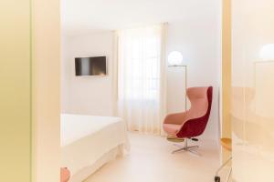 a room with a bed and a chair and a mirror at Fonda Llabres Boutique in Alcudia