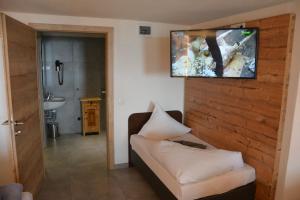 a living room with a couch and a television on a wall at Clubdorf Hotel Alpenrose in Galtür