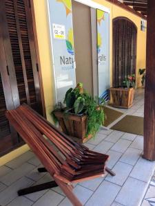 a wooden bench sitting in front of a building at Hotel Naturalis in Paranaguá