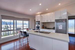 a kitchen with white cabinets and a large window at Esperance Landing in Dover