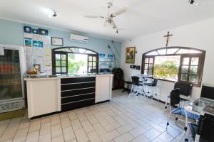 a kitchen with a counter and some chairs and windows at Hotel Naturalis Eireli in Paranaguá