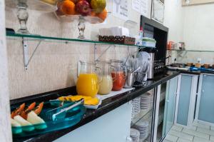 a kitchen counter with a bunch of fruits and juice at Hotel Naturalis in Paranaguá