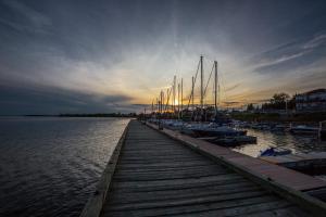 a dock with boats docked in the water at sunset at RépitBonka et Vélo - Péribonka in Peribonka
