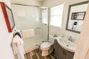 a bathroom with a shower toilet and a sink at Island View Cottages Sebastian in Sebastian