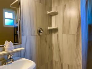 a bathroom with a sink and a shower with a mirror at Lakeside Inn and Cafe in Saint Cloud