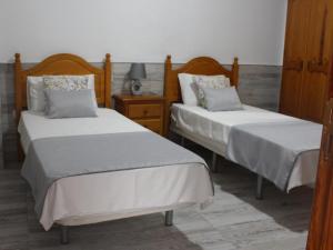 een slaapkamer met 2 bedden en een nachtkastje bij Yanez Sweet Home Valsequillo de GC in Valsequillo