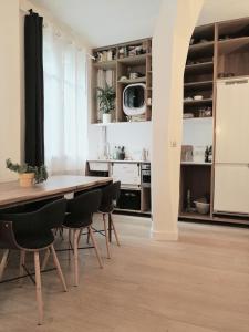 eine Küche mit einem Tisch und Stühlen im Zimmer in der Unterkunft Beautiful family flat nearby the Flea Market, Stade de France, Montmartre in Saint-Ouen