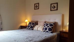 Un dormitorio con una cama con almohadas azules y blancas. en Alvor Navy Apartment, en Alvor 30 fotos más