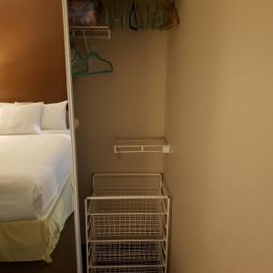 um pequeno quarto com uma cama e um closet em Shemron Suites Hotel em Deep River