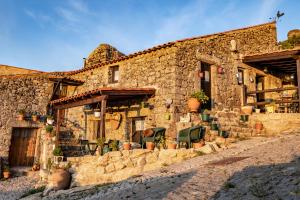 un edificio de piedra con plantas delante de él en Old House en Monsanto