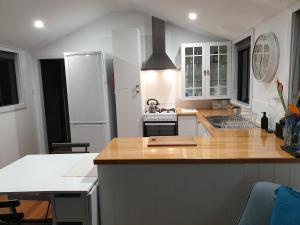 una cucina con armadi bianchi e piano di lavoro di Charolais Cottage a Picton