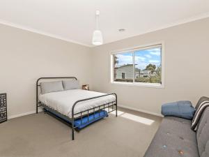 Schlafzimmer mit einem Bett und einem Fenster in der Unterkunft Little Croft in Port Fairy