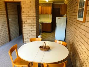 
a kitchen with a table and a refrigerator at Flat 2 - 3 Bay Lane in Kianga
