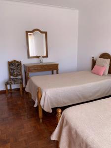 a room with two beds and a mirror and a chair at Apartamentos Sonybell in Albufeira