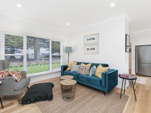 a living room with a blue couch and a tv at Marlow House in Port Fairy