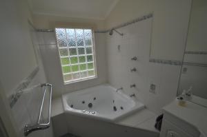 
a white bath tub sitting next to a white sink at 12 Bluewater Drive in Kianga
