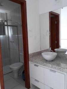 a white bathroom with a sink and a toilet at condomínio Mar da Galiléia in Coroa Vermelha