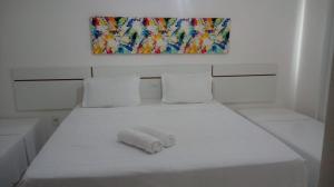 a white bed with a towel on top of it at condomínio Mar da Galiléia in Coroa Vermelha +17 photos