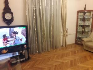 uma sala de estar com uma televisão de ecrã plano e piso em madeira em SAHIL GARDEN Uzeir Gadgibekova Street em Baku