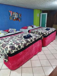dos camas sentadas una al lado de la otra en una habitación en hotel kasa kamelot 2, en Quetzaltenango