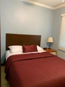 1 dormitorio con 1 cama grande con manta roja en Lakeside Inn and Cafe, en Saint Cloud