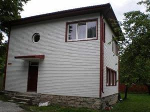 Vabriku Guesthouse في تالين: منزل أبيض صغير مع نافذة وباب