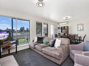 a living room with a couch and a tv at Moyne Views 2 in Port Fairy