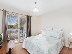 a bedroom with a bed and a large window at Moyne Views 2 in Port Fairy