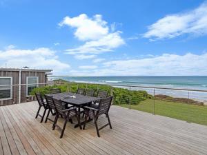 a table and chairs on a deck with a view of the ocean at ONE FISH, TWO FISH in Port Fairy