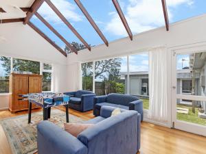 a living room with blue furniture and large windows at ONE FISH, TWO FISH in Port Fairy