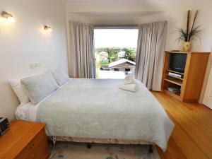 een slaapkamer met een bed met een teddybeer erop bij Paradise Cove in Port Fairy