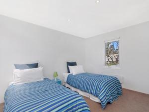 two beds in a room with white walls at Riverend Regent in Port Fairy
