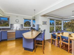 a kitchen with blue cabinets and a table and chairs at Rossleague House in Port Fairy