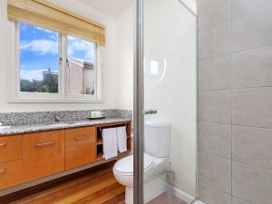 a bathroom with a toilet and a glass shower at RUBY'S BEACHFRONT in Port Fairy