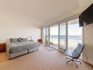 a bedroom with a bed and a view of the ocean at Rubys Beachfront in Port Fairy