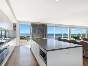 a white kitchen with a view of the ocean at Saltwater Lodge in Port Fairy
