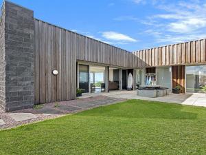 a large wooden building with a lawn in front of it at Saltwater Lodge in Port Fairy